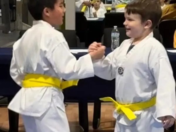 Two young students in yellow belts practising a partner drill together.